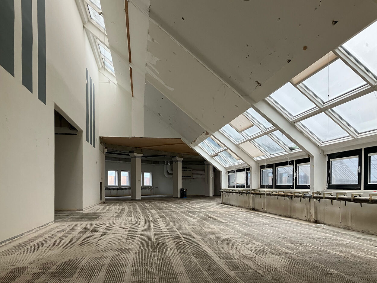 Left: Picture showing one of the floors with the triangular service core in the center. Right: Picture of one of the top floors, with a higher sloped ceiling and skylight. Both pictures are taken of the building in the state of a soft strip of materials and with the glazed facade on the right side. © Line Kjær Frederiksen.