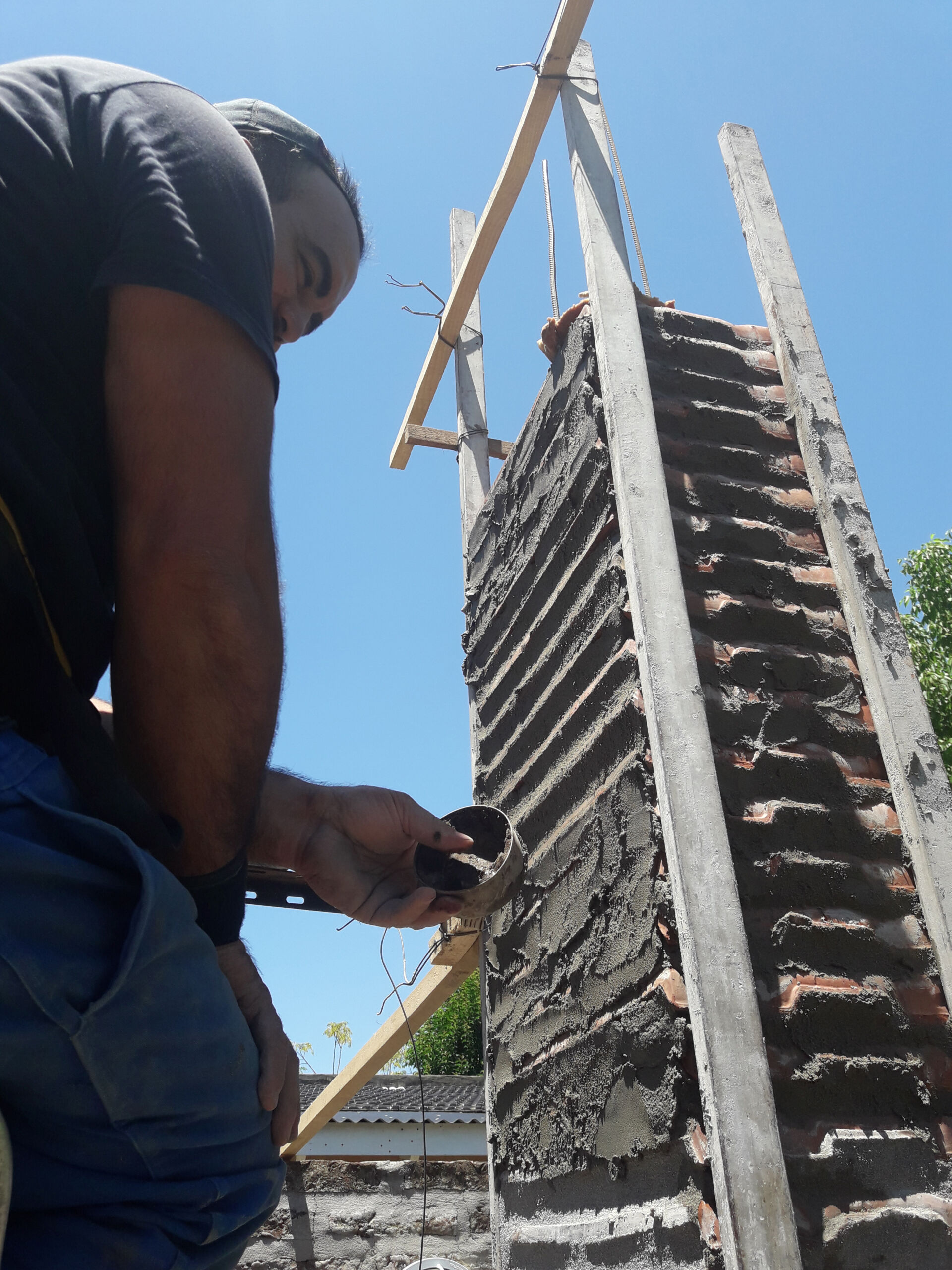 Construction of column project at Casa Yaraví by OTRO. Builder using a tuna can to smooth the cement mortar joints. Buenos Aires, Argentina. Photo courtesy of Juan Pablo Berbery.
